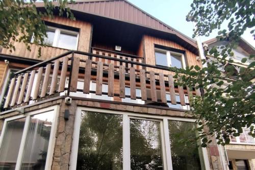 einen Balkon auf dem Dach eines Hauses mit Fenstern in der Unterkunft Winterheim Sonnenberg in Tetovo