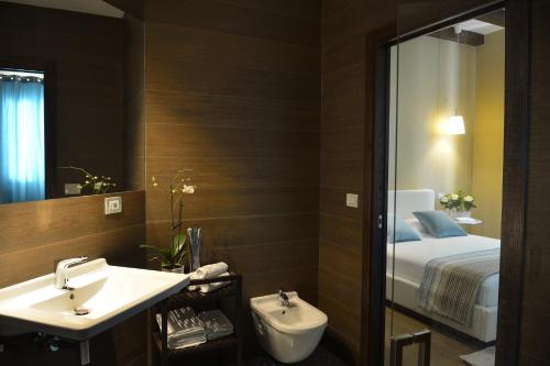 La salle de bains est pourvue d'un lavabo, d'un lit et d'un miroir. dans l'établissement Baglio Caruana Cantina & Relais, à Montallegro