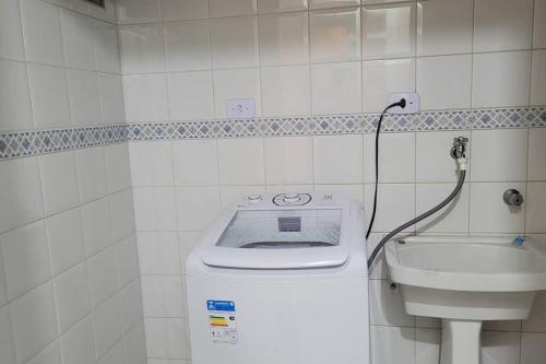 Baño blanco con aseo y lavamanos en Apartamento 2 quartos sendo 1 Suíte en Pindamonhangaba