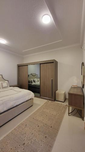 una camera da letto con un letto grande, una scrivania e un letto sidx sidx di شقة فاخرة Vip غرفتين وجلسة خارجية - وصول ذاتي a Riyad