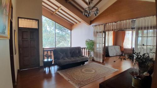 a living room with a couch and some windows at Villa Dinar Tulip VIB in Lembang