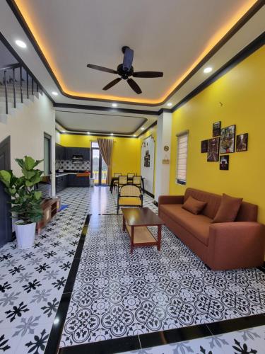 - un salon avec un canapé et un ventilateur de plafond dans l'établissement Quê hương Villa (Indochine Villas Tam Chau), à Bảo Lộc