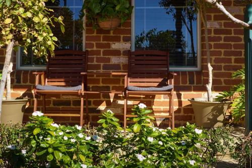 two chairs sitting in front of a brick house at Durham Lodge Bed & Breakfast in Perth