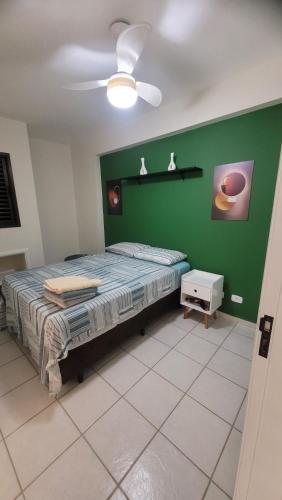 1 dormitorio con cama y pared verde en Apartamento 2 quartos sendo 1 Suíte, en Pindamonhangaba