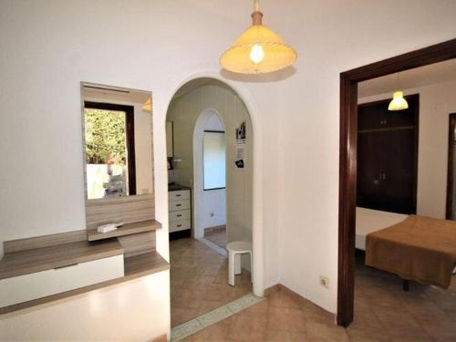 a room with a bedroom with a table and a mirror at Apartments La Pineda, Playa de Pals in Begur