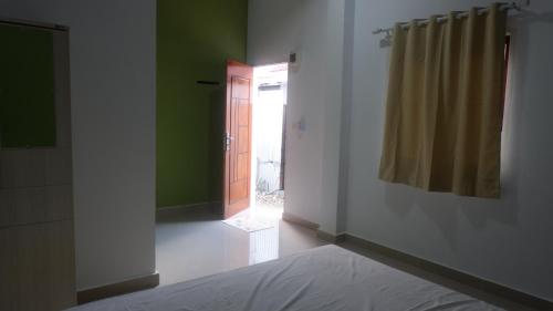 ein Schlafzimmer mit einem Bett und eine Tür mit einem Fenster in der Unterkunft Maria Guesthouse in Mandati
