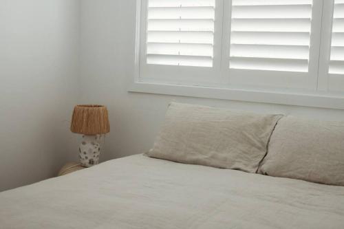 a bed with a pillow and a window in a bedroom at Silver Linings Apartment - Hosted by Burleigh Letting in Gold Coast