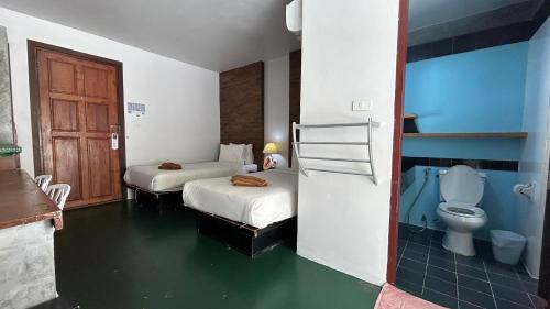 a hotel room with two beds and a toilet at PP Insula in Phi Phi Islands