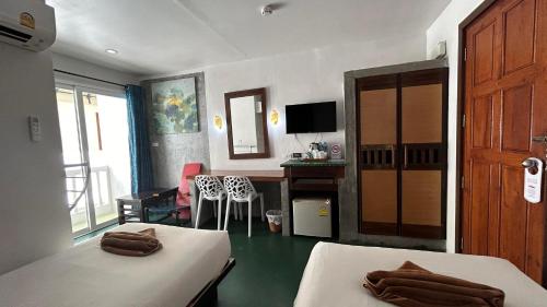 a hotel room with two beds and a desk and a room at PP Insula in Phi Phi Islands