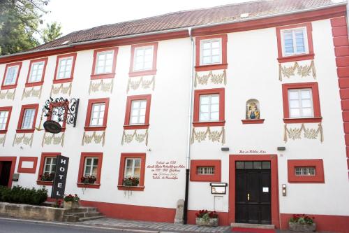 biały budynek z czerwonymi akcentami w obiekcie Hotel Zum Goldenen Anker w mieście Bamberg
