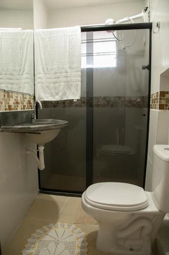 a bathroom with a shower and a toilet and a sink at A Oca Hostel in João Pessoa
