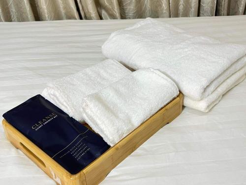 a stack of towels on top of a bed at Sakura apartment in Manila