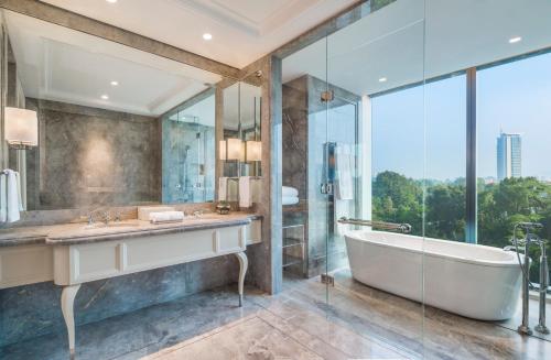 a bathroom with a tub and a sink and a shower at The St. Regis Kuala Lumpur in Kuala Lumpur
