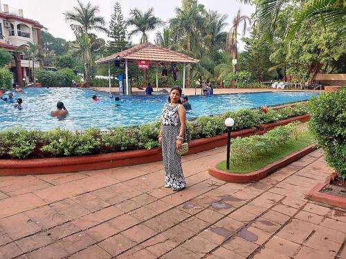 a woman standing in front of a swimming pool at Jubilee hotel in Calangute