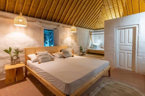 1 dormitorio con 1 cama grande en una habitación en Ekant The Organic Farmstay, en Kālādhūngi