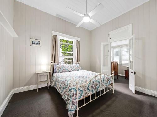 um quarto branco com uma cama e uma janela em Kilmallie em Maclean