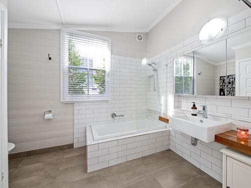ein weißes Badezimmer mit einer Badewanne und einem Waschbecken in der Unterkunft Kilmallie in Maclean