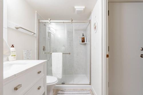 a white bathroom with a shower and a toilet at Seasons at Leschi Hillsides in Seattle