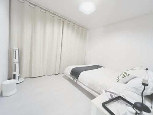 ソウルにあるSeoul Namsan Stayの白いベッドルーム(ベッド1台、窓付)