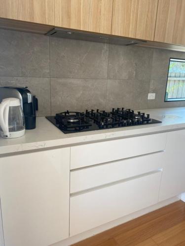 a kitchen with a stove top on a counter at Bonbeach Beauty in Bonbeach