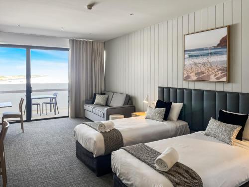 a hotel room with two beds and a view of the ocean at Direct Collective - Bli Bli Suites in Bli Bli