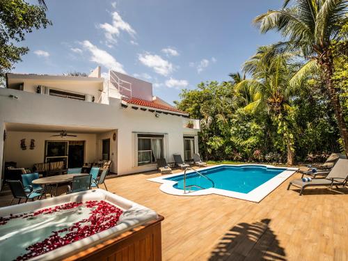 a backyard with a swimming pool and a house at Villa Beach Adventure Relax Holiday Private Pool BBQ Maid Service Golf in Playa del Carmen