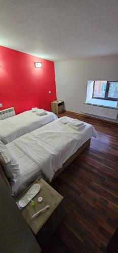 a room with two beds and a red wall at RO METRO in Gyumri
