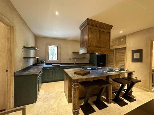 a kitchen with green cabinets and a wooden table at Villa Serena Val’Quirico in Santeagueda