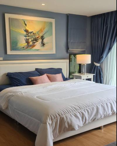 1 dormitorio con 1 cama grande y paredes azules en บ้านสวนภาคินรัตน์ 