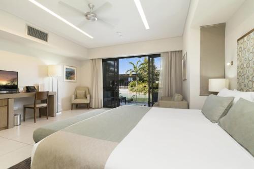 1 dormitorio con 1 cama grande, escritorio y ordenador en Mindil Beach Casino Resort, en Darwin