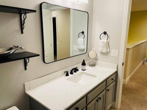a bathroom with a sink and a large mirror at Sopra Bella- 4 bedroom home in Corvallis