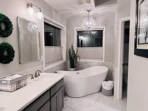 Baño blanco con bañera y lavamanos en Sopra Bella- 4 bedroom home, en Corvallis