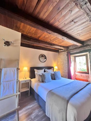 - une chambre avec un grand lit et un plafond en bois dans l'établissement Hôtel Les Vieilles Tours Rocamadour, à Rocamadour
