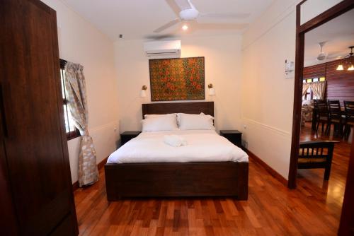 ein Schlafzimmer mit einem Bett und einem Wandgemälde in der Unterkunft Rimba Alor Orchard Villas Villa Alor 