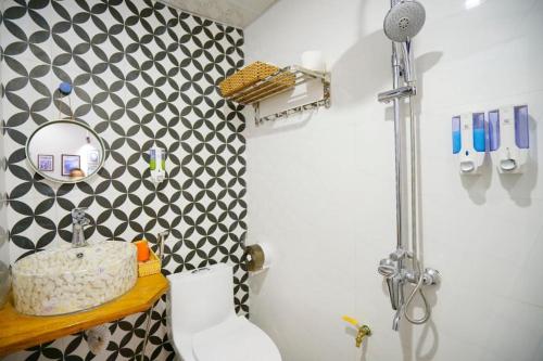 baño con pared estampada en blanco y negro en Almor Homestay 2 Food, Bread & Coffee HaLong, en Ha Long