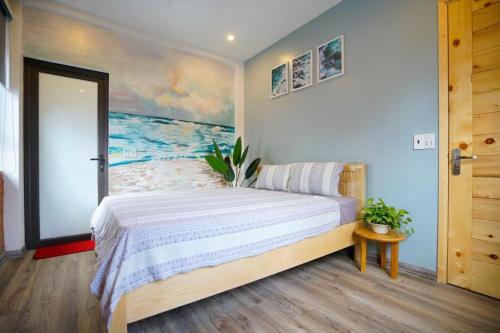 1 dormitorio con 1 cama con una pintura en la pared en Almor Homestay 2 Food, Bread & Coffee HaLong, en Ha Long
