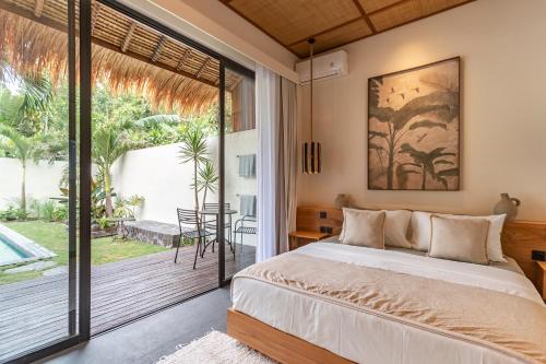 a bedroom with a bed and a sliding glass door at Villa Jodoh - Exciting Chic 4BR Stylish Villa Near Seminyak, Perfect for a Trendy Getaway in Kerobokan