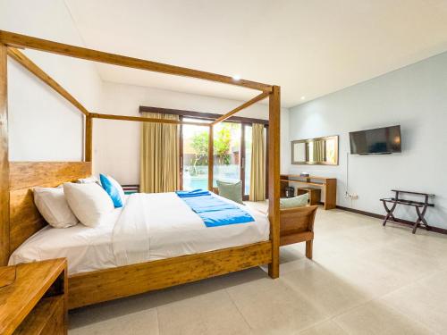 een slaapkamer met een groot bed met een houten frame bij Villa Echo Taman Bali in Canggu