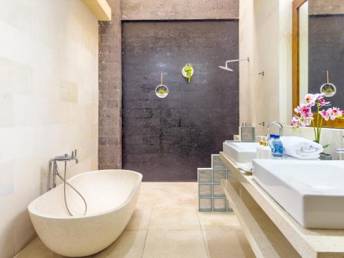 a bathroom with two sinks and a tub at Villa Echo Taman Bali in Canggu