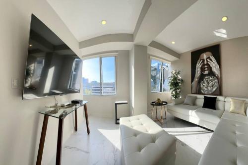 a living room with a white couch and a tv at The best place to live and work in Mexico City