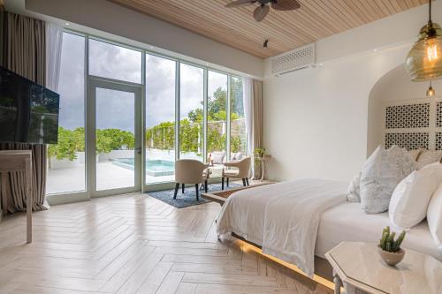 a bedroom with a large bed and a living room at Malahini Kuda Bandos Resort in North Male Atoll