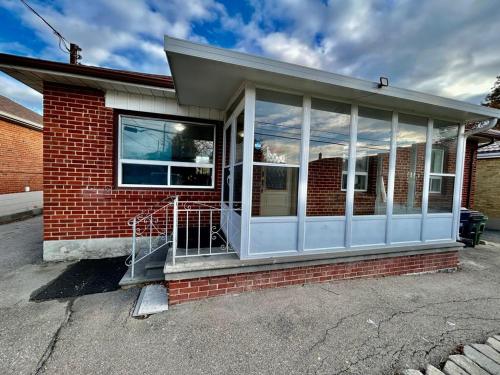 a red brick house with a porch and windows at Toronto Uptown 1 - Bus to Downtown in Toronto