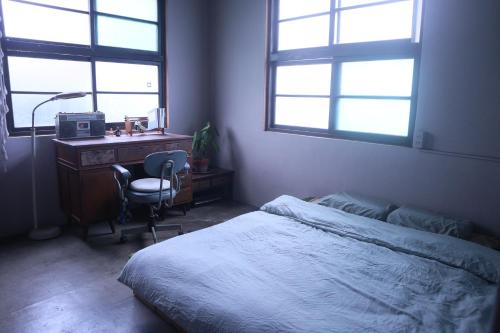 a bedroom with a bed and a desk with a computer at Everythingsoup in Changhua City
