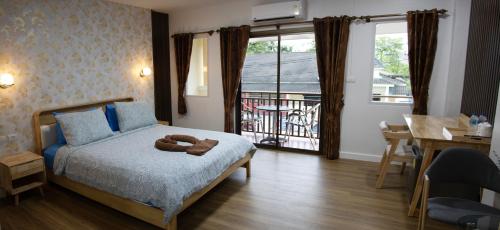 a bedroom with a bed with a teddy bear on it at Thai Life Guesthouse Khaolak in Khao Lak