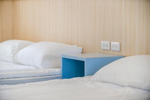 two beds with white pillows and a blue table at White House in Xiaoliuqiu
