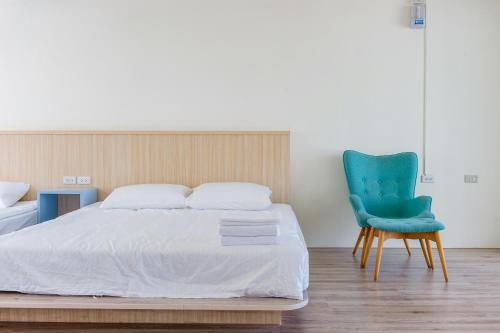 a bedroom with a bed and a blue chair at White House in Xiaoliuqiu
