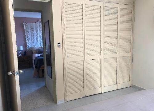 a room with a closet with white doors and a bedroom at Marbella in Irapuato