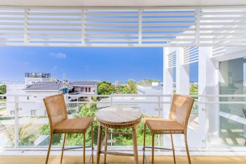 a table and two chairs on a balcony with a view at White House in Xiaoliuqiu