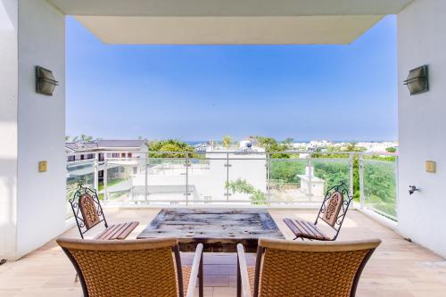 a patio with a table and chairs and a balcony at White House in Xiaoliuqiu