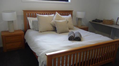uma cama com dois pares de sapatos em cima em Spacious House Close to Hobart CBD WiFi and New Sony QLED Smart TV em Moonah